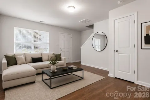 a living room with furniture a large window and a mirror