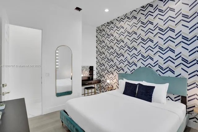 a bedroom with furniture and a large window