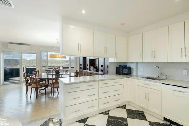 a dining room with wooden floor a chandelier and windows