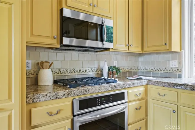 a kitchen with stainless steel appliances granite countertop white cabinets and a stove