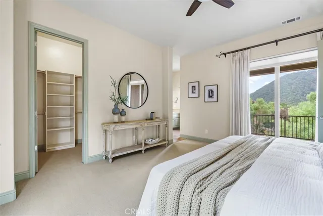 a bedroom with a bed a ceiling fan and a large window