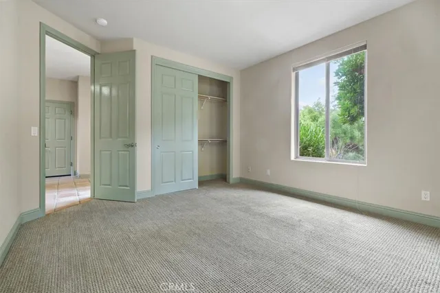 an empty room with windows and closet