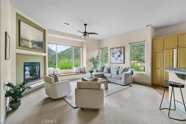 a living room with furniture large window and flat screen tv