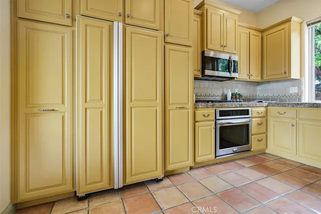 a kitchen with stainless steel appliances granite countertop a stove a sink and a refrigerator