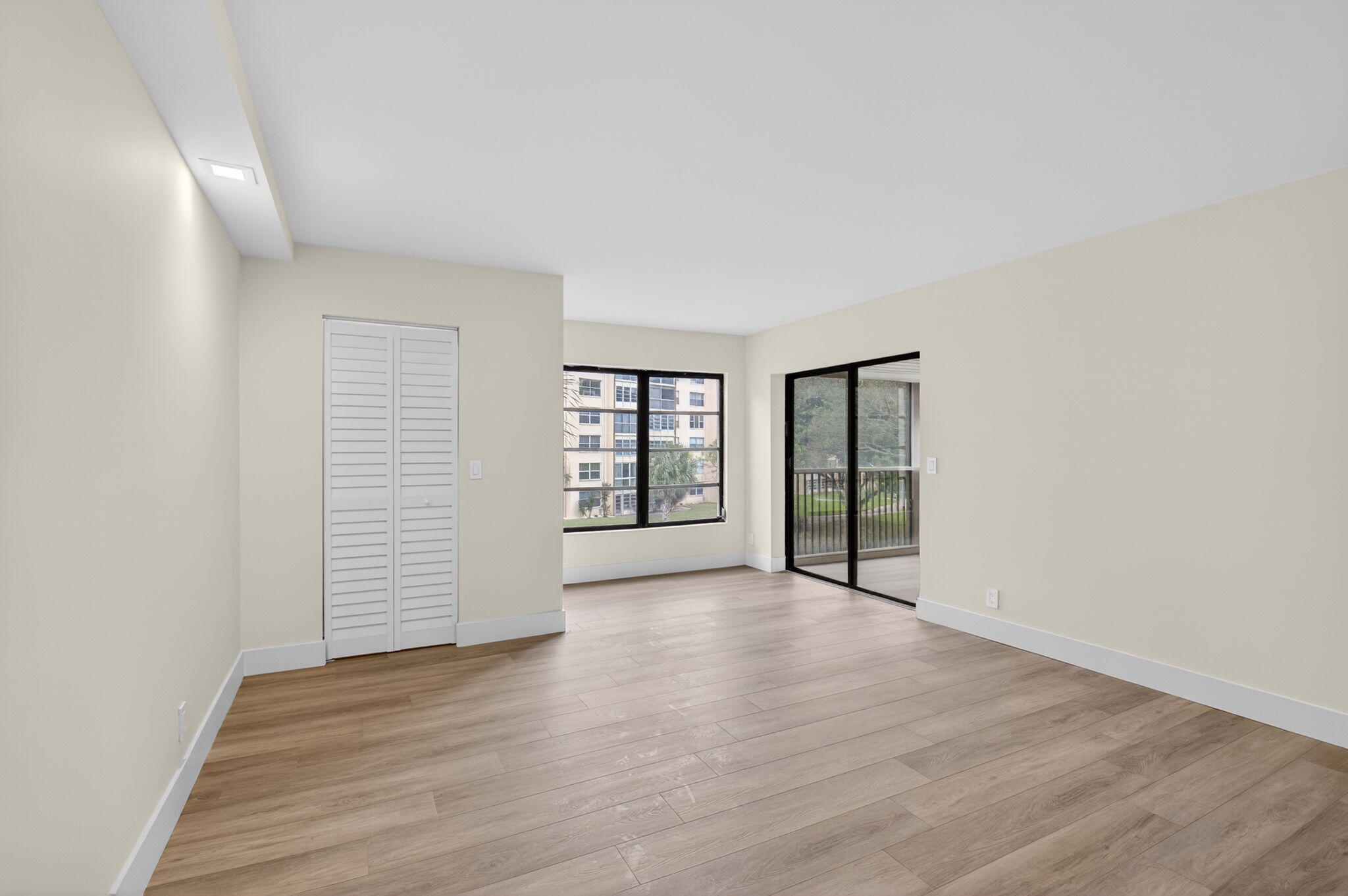 14475 Strathmore Lane, Unit 305 Delray Beach, FL 33446 - Photo 12 of 27 an empty room with wooden floor and windows