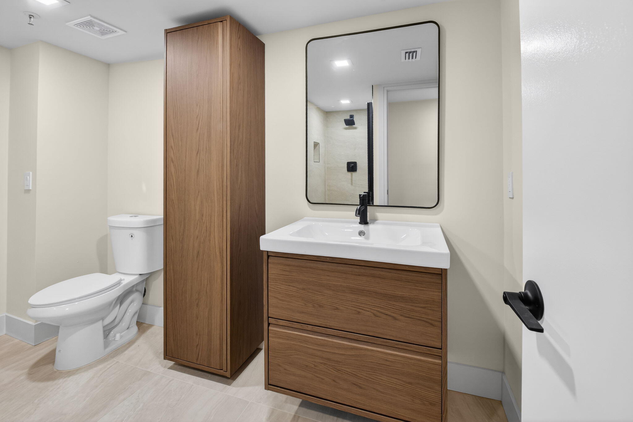 14475 Strathmore Lane, Unit 305 Delray Beach, FL 33446 - Photo 22 of 27 a bathroom with a sink a toilet and a mirror