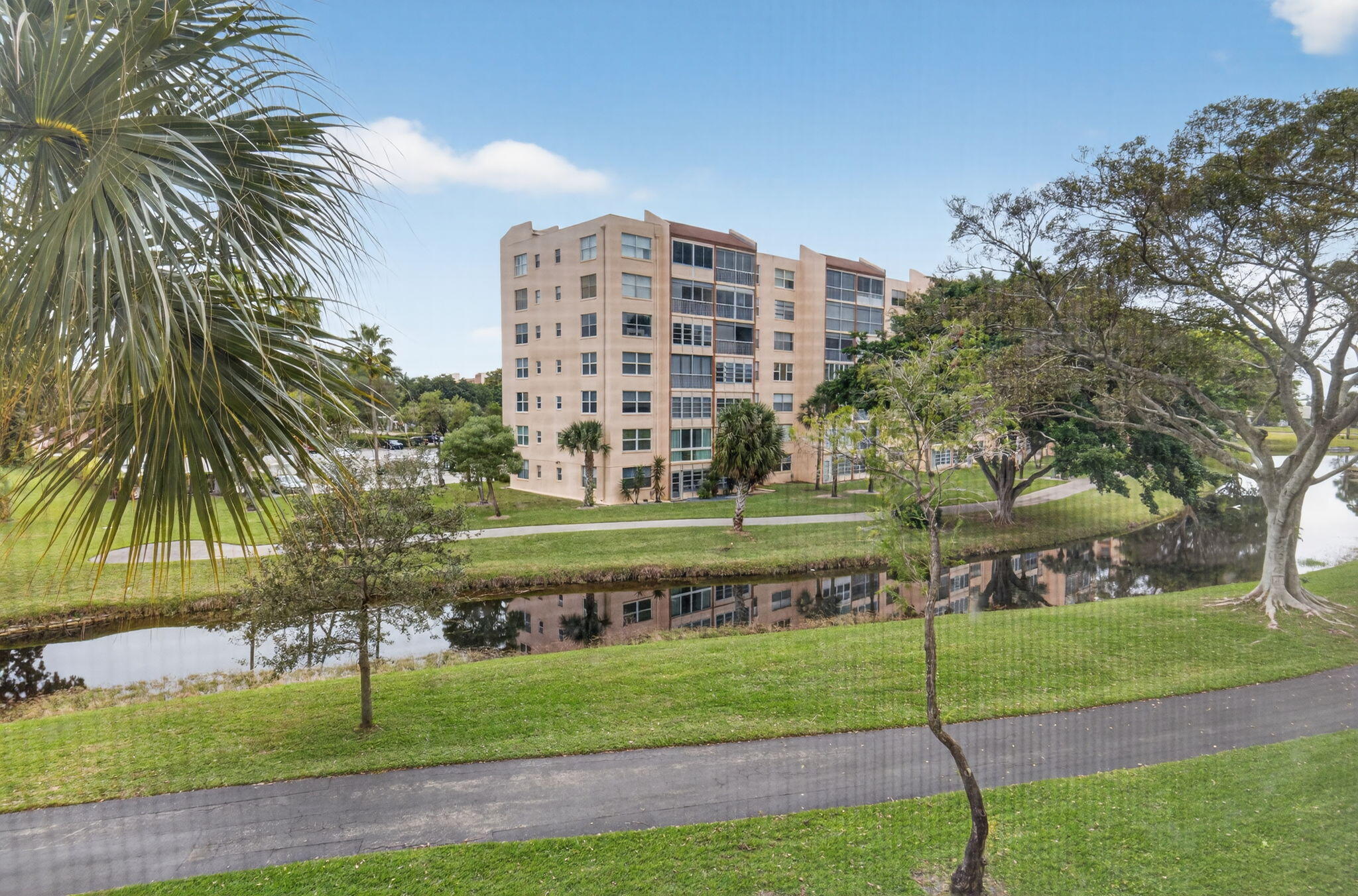 14475 Strathmore Lane, Unit 305 Delray Beach, FL 33446 - Photo 24 of 27 a view of a tall building with a yard