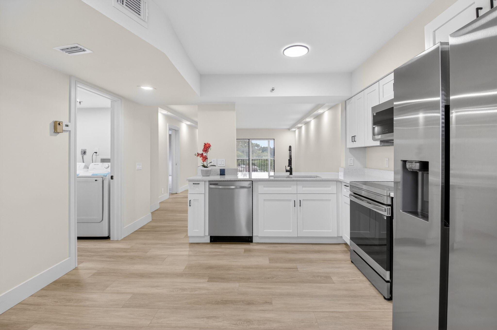 14475 Strathmore Lane, Unit 305 Delray Beach, FL 33446 - Photo 5 of 27 a kitchen with a refrigerator sink and cabinets
