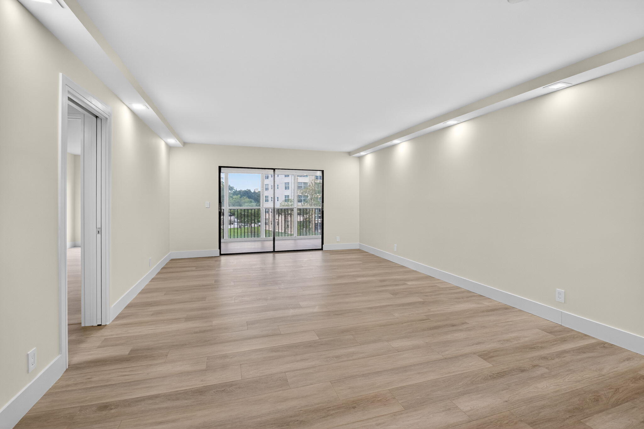 14475 Strathmore Lane, Unit 305 Delray Beach, FL 33446 - Photo 6 of 27 a view of an empty room with wooden floor and a window