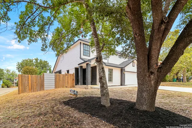 a front view of a house with a tree