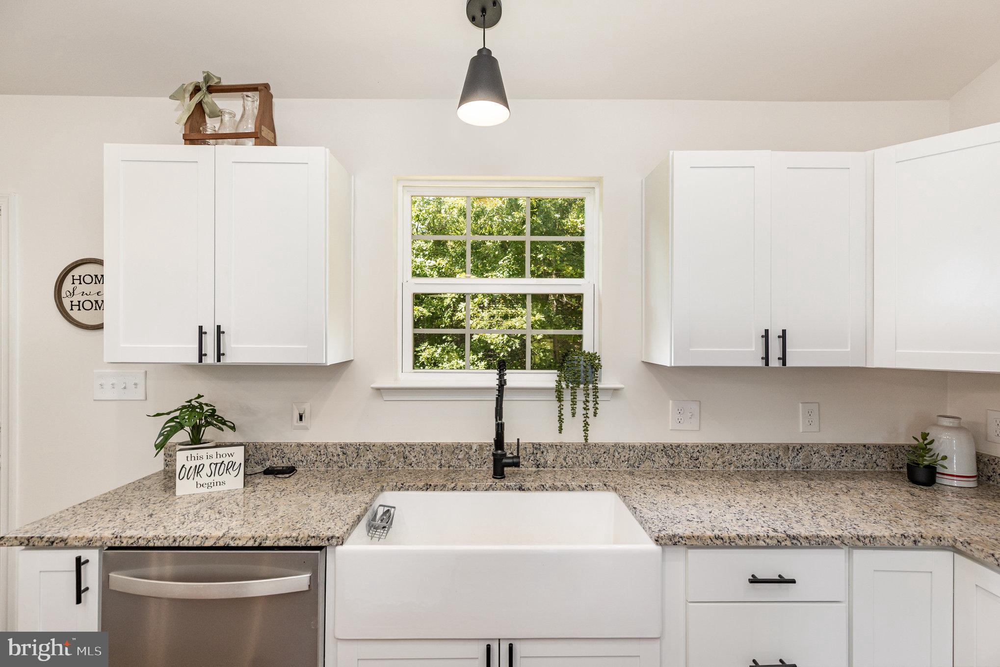 5224 Pendleton Farm Road Bumpass, VA 23024 - Photo 12 of 31 a kitchen with granite countertop a sink white cabinets and a window