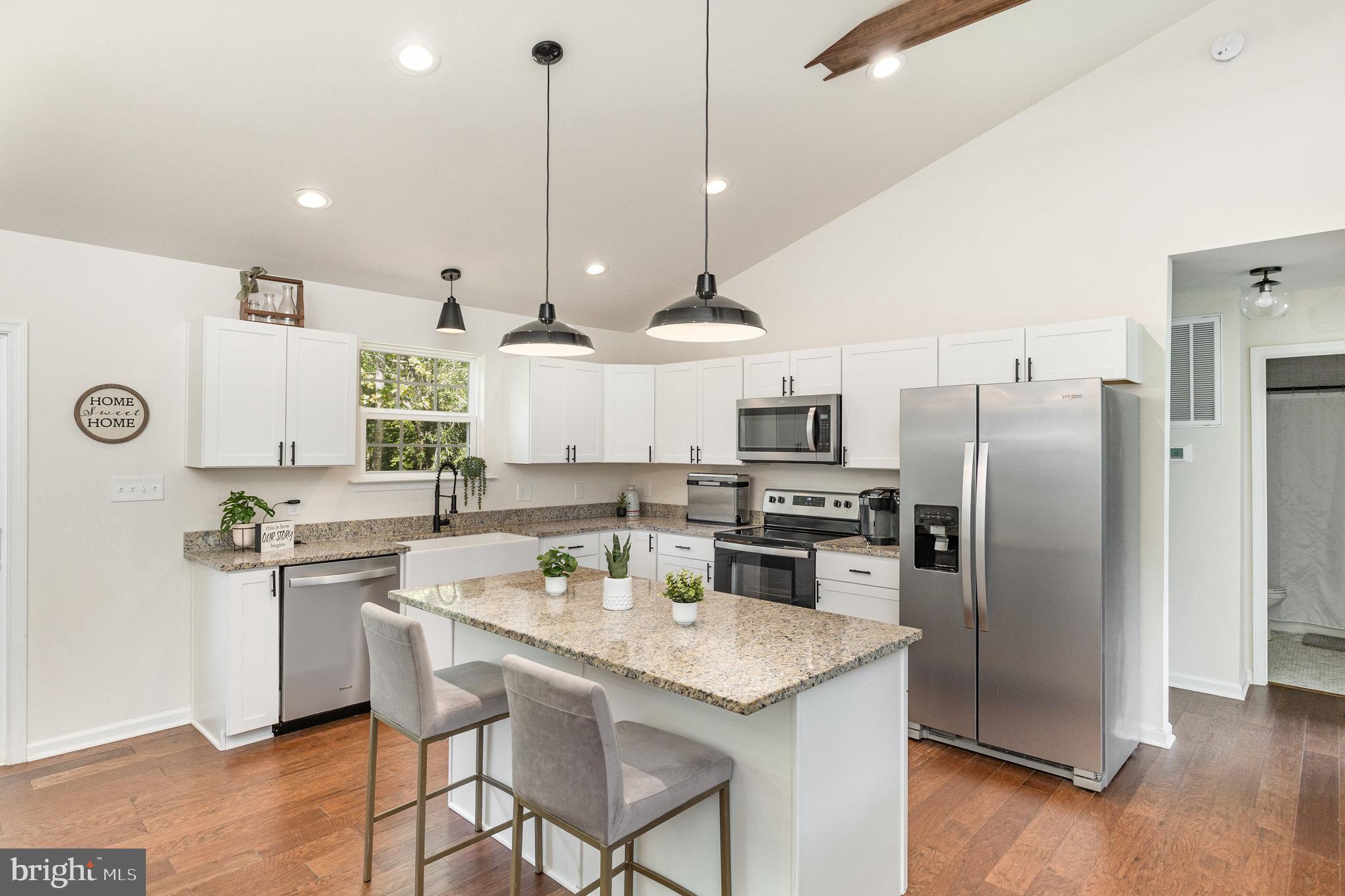 5224 Pendleton Farm Road Bumpass, VA 23024 - Photo 5 of 31 a kitchen with stainless steel appliances kitchen island granite countertop a refrigerator a sink a stove and chairs with wooden floor