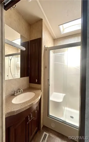 a bathroom with a sink a mirror and a shower