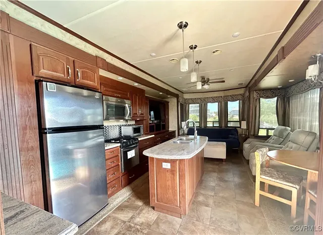 a kitchen with stainless steel appliances granite countertop a sink refrigerator and cabinets