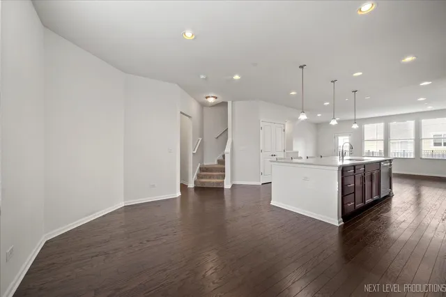 a view of kitchen with kitchen island refrigerator wooden floor and center island