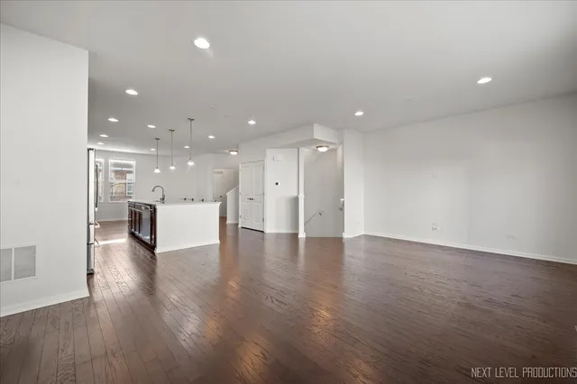 a view of a big room with wooden floor and a kitchen