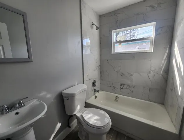 a white toilet sitting next to a bath tub