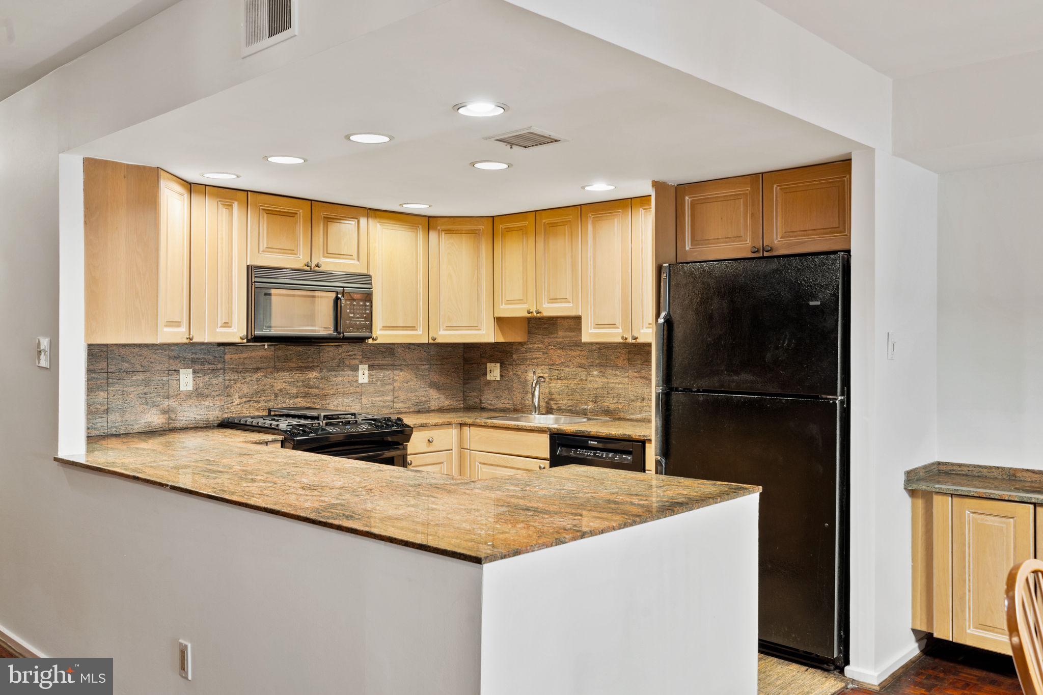 233 Monroe Street Philadelphia, PA 19147 - Photo 8 of 51 a kitchen with kitchen island granite countertop a sink a counter top space and cabinets