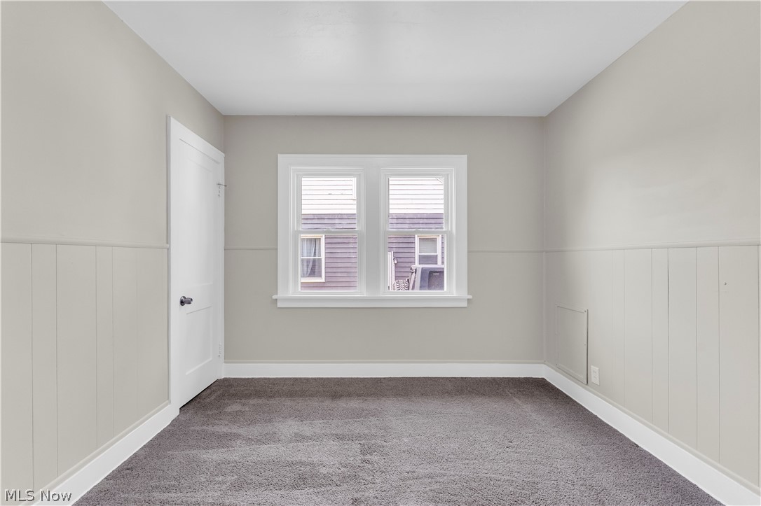 18123 McCracken Road Maple Heights, OH 44137 - Photo 14 of 27 Room featuring a two-panel interior door, baseboard trim, and a window with blinds