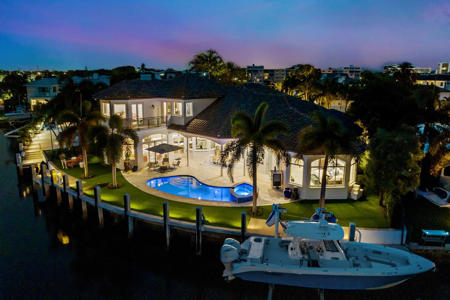 750 Northeast 37th Street Boca Raton, FL 33431 - Photo 38 of 50 a patio with tables and chairs pool and a fire pit with wooden floor