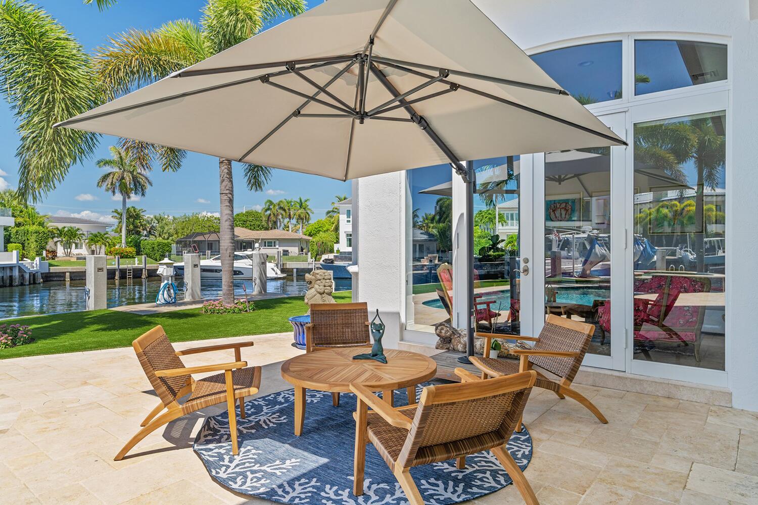 750 Northeast 37th Street Boca Raton, FL 33431 - Photo 8 of 50 a patio with a table and chairs under an umbrella