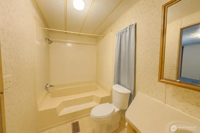 a bathroom with a toilet and a shower