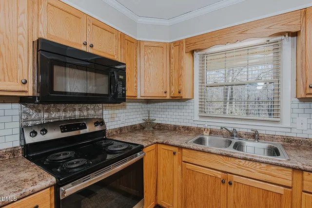 a kitchen with granite countertop a stove sink and microwave