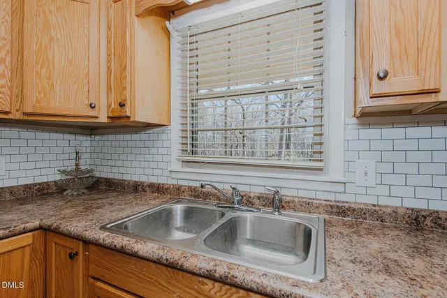 a kitchen with granite countertop a sink and cabinets