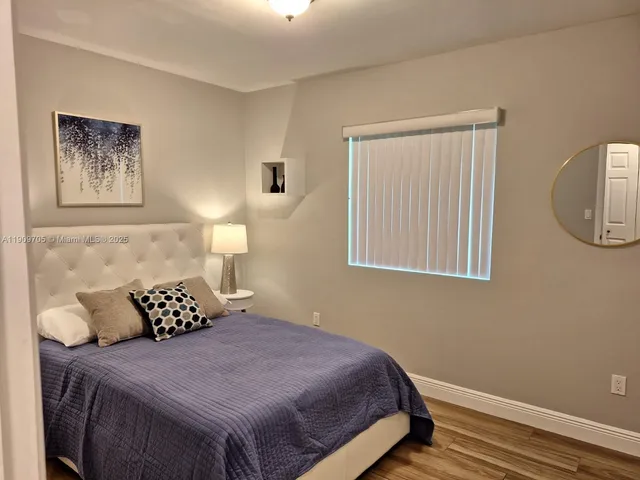 a bedroom with a bed and painting on wall