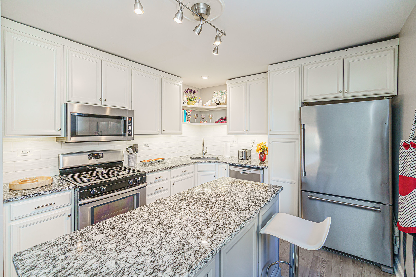 170 Old Mill Grove Road Lake Zurich, IL 60047 - Photo 11 of 23 a kitchen with a refrigerator a stove and white cabinets with wooden floor
