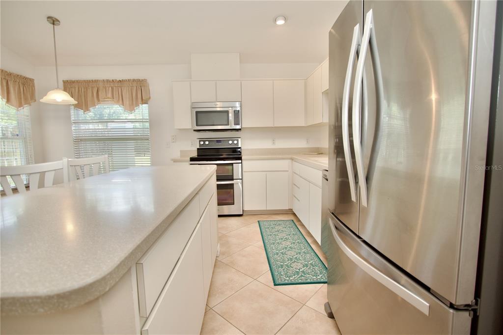 7842 Tenby Court New Port Richey, FL 34655 - Photo 12 of 27 a kitchen with stainless steel appliances granite countertop a refrigerator a oven and white cabinets