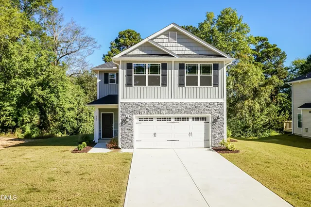 a front view of a house with a yard and garage