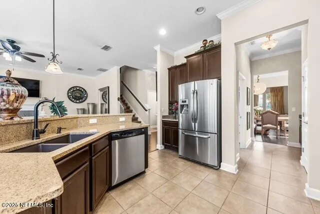 a kitchen with stainless steel appliances granite countertop a sink a stove and a refrigerator