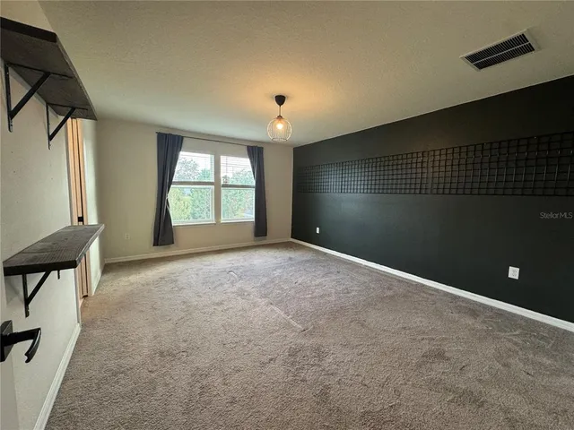 en empty room with windows and chandelier