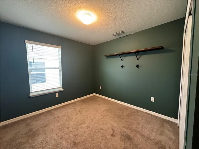 an empty room with closet and mirror