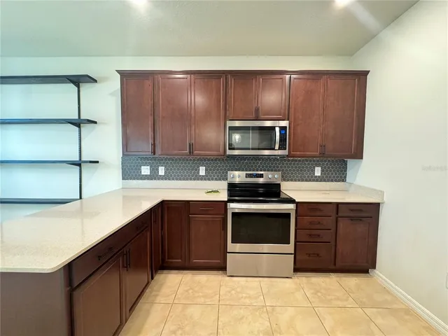 a kitchen with stainless steel appliances granite countertop a stove microwave and cabinets