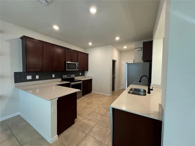 a kitchen with stainless steel appliances a stove sink microwave and cabinets