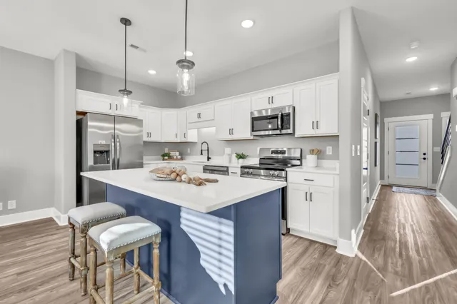 a kitchen with kitchen island a sink stove and refrigerator