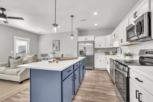 a kitchen with stainless steel appliances kitchen island granite countertop a sink a stove top oven a counter space and cabinets