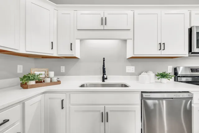 a kitchen with white cabinets and a sink