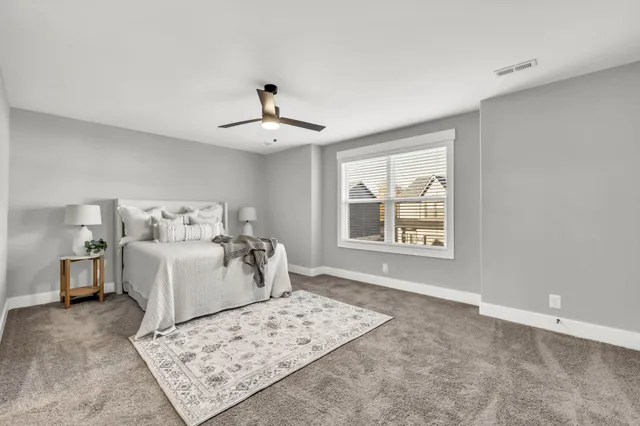 a bedroom with a large bed and a chandelier
