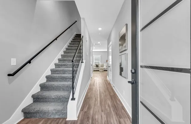 a view of a hallway with wooden floor and staircase