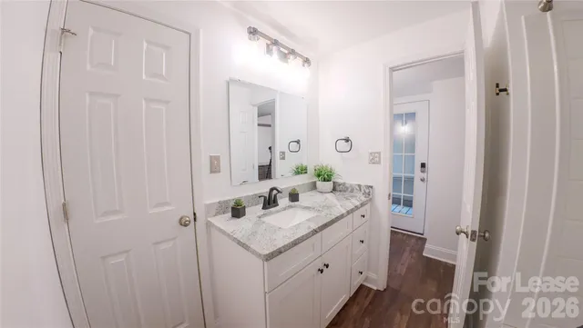 a bathroom with a granite countertop sink and a mirror
