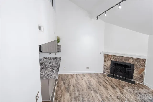 a view of empty room with wooden floor and fireplace