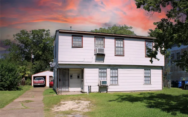 a front view of a house with a garden and garage