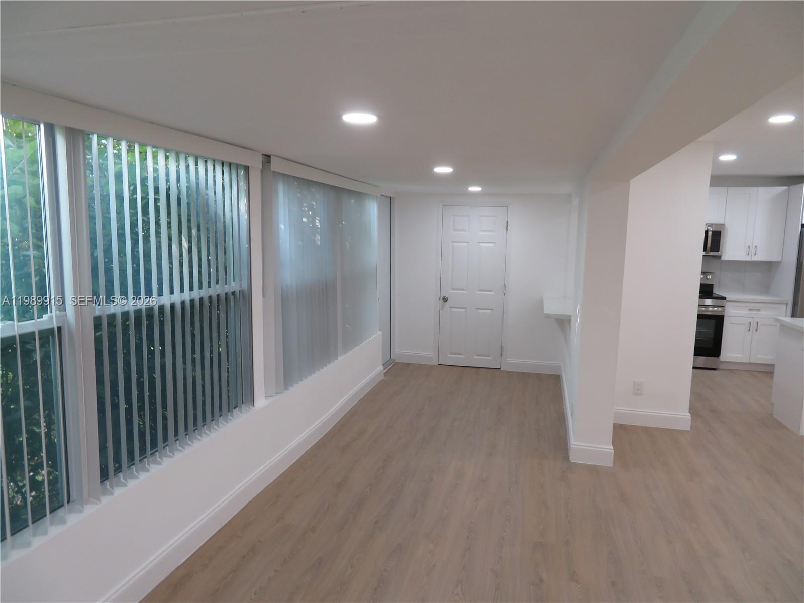 17247 Southwest 112th Place, Unit 21044 Miami, FL 33157 - Photo 11 of 21 a view of empty room with wooden floor and windows