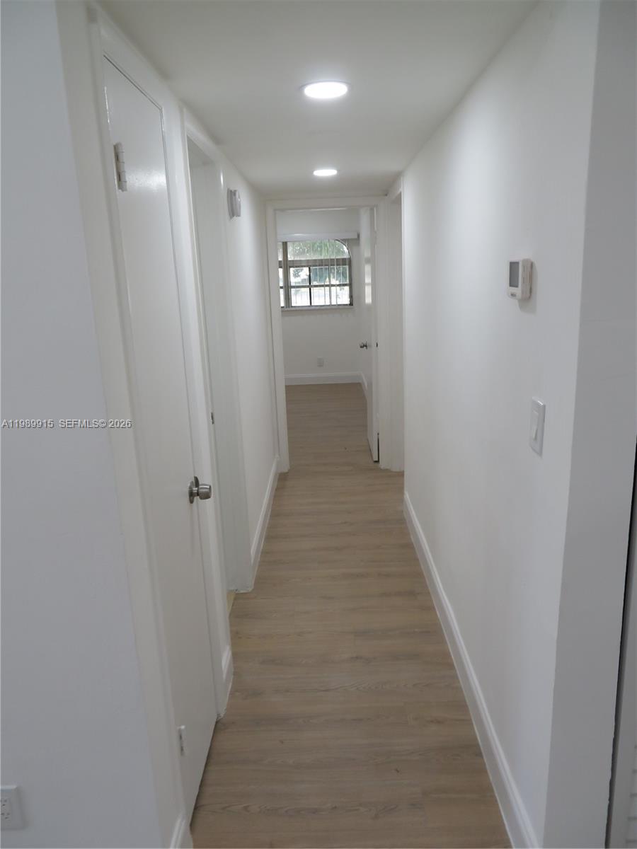 17247 Southwest 112th Place, Unit 21044 Miami, FL 33157 - Photo 13 of 21 a view of a hallway with wooden floor and a bathroom