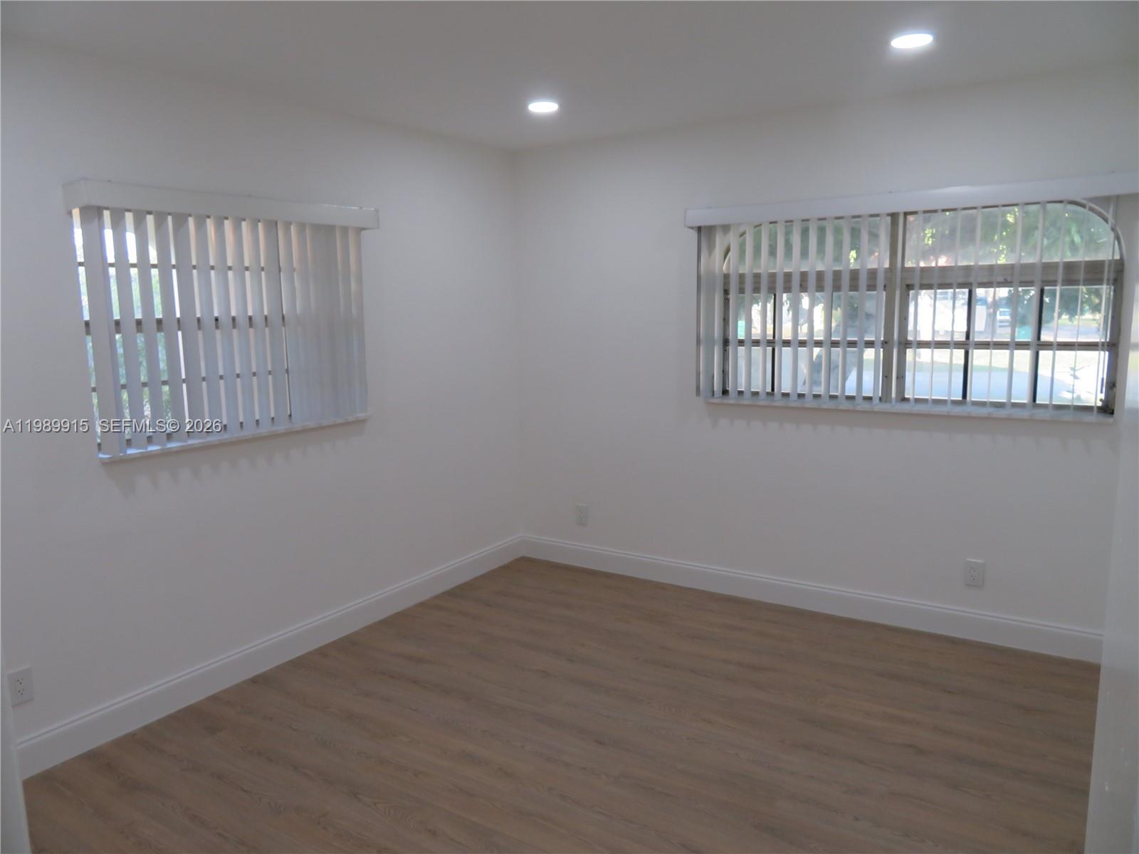 17247 Southwest 112th Place, Unit 21044 Miami, FL 33157 - Photo 14 of 21 wooden floor in an empty room with a window