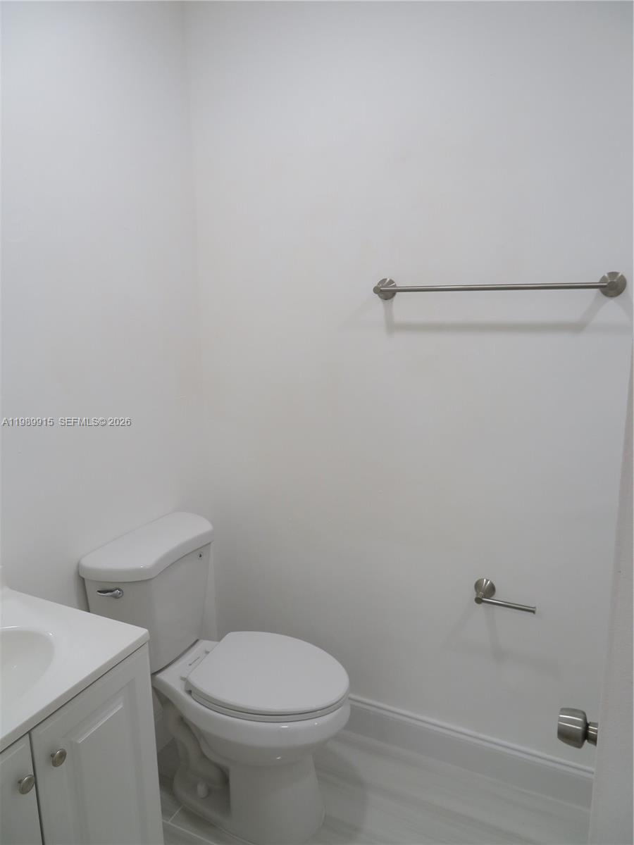 17247 Southwest 112th Place, Unit 21044 Miami, FL 33157 - Photo 18 of 21 a white toilet sitting next to a bathroom sink
