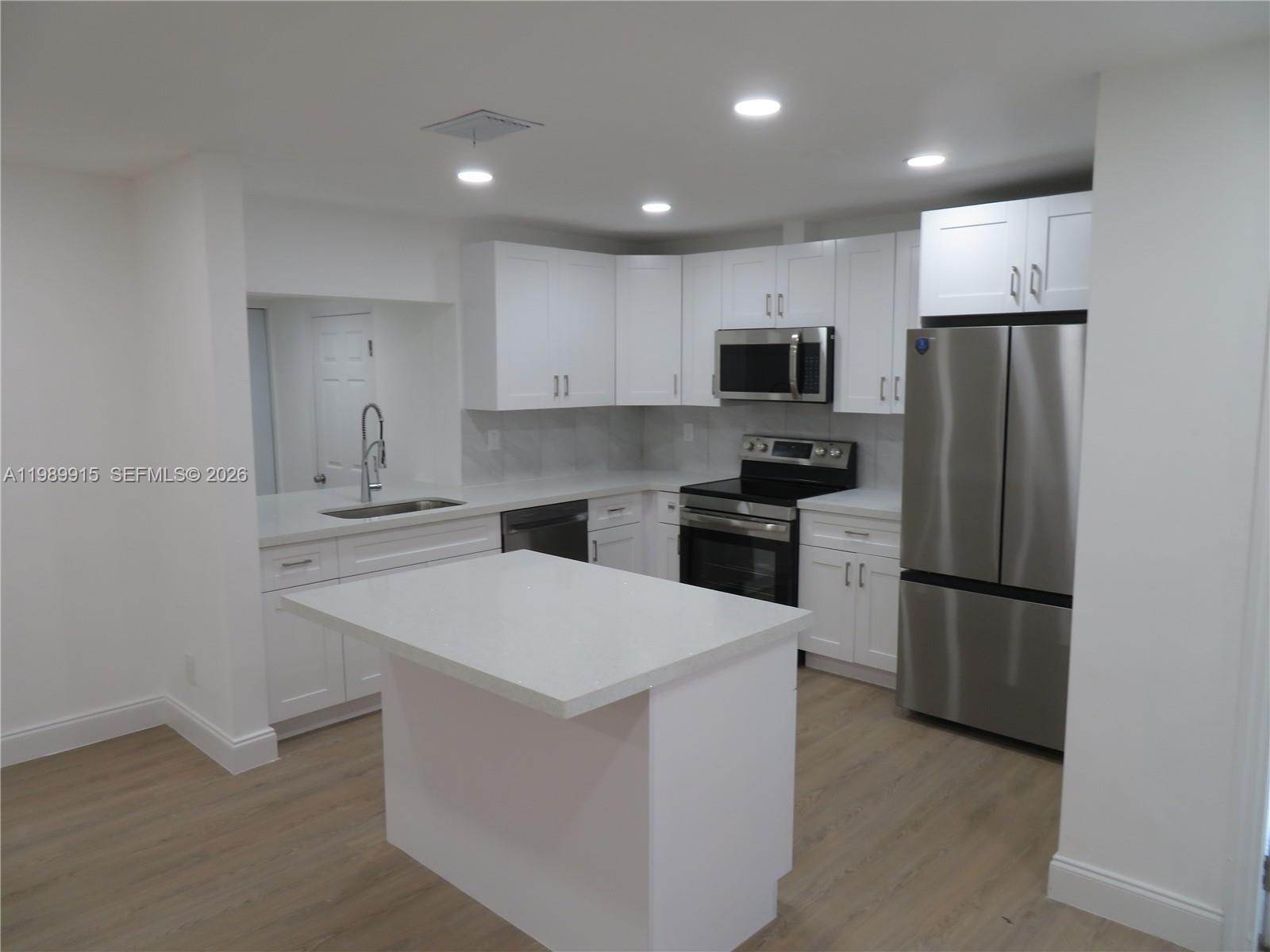 17247 Southwest 112th Place, Unit 21044 Miami, FL 33157 - Photo 6 of 21 a kitchen with a refrigerator a stove top oven and a sink